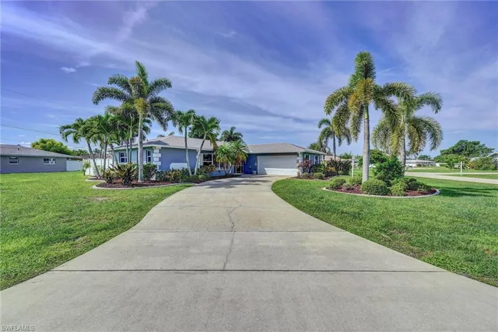 Single story home with driveway, a garage, a front yard, and stucco siding