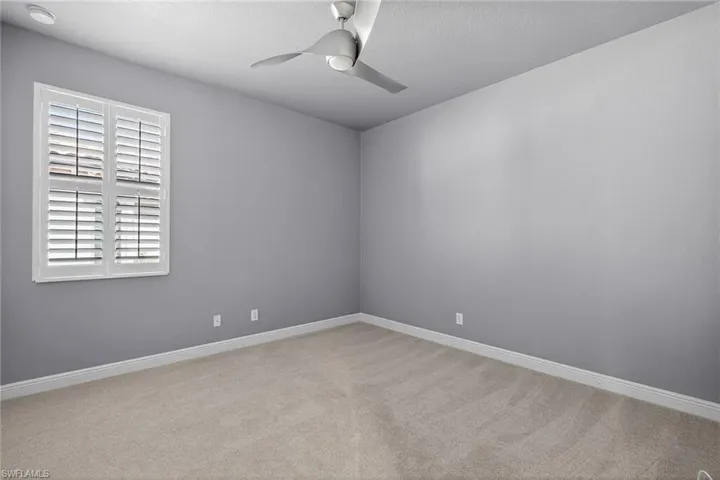 Guest bedroom 2 with plantation shutters, ceiling fan and carpeting