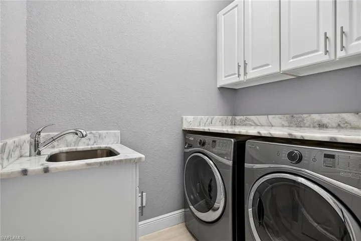 Laundry room with Whirlpool washer and dryer, wet sink, cabinet and pantry