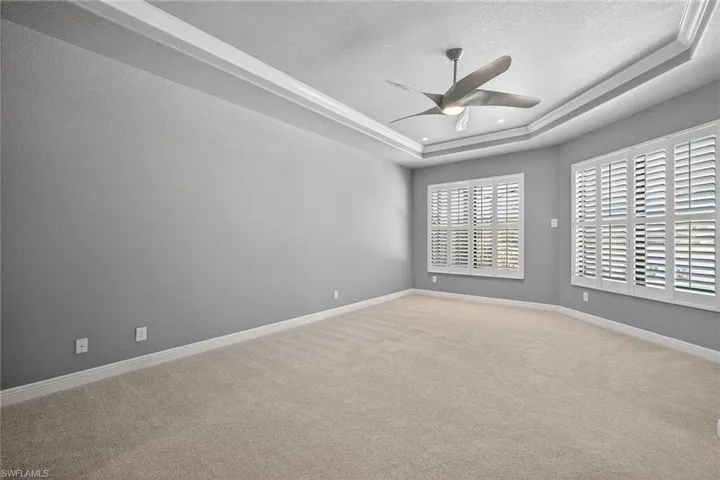 Primary Suite with ceilings fan, plantation shutters and fresh carpeting