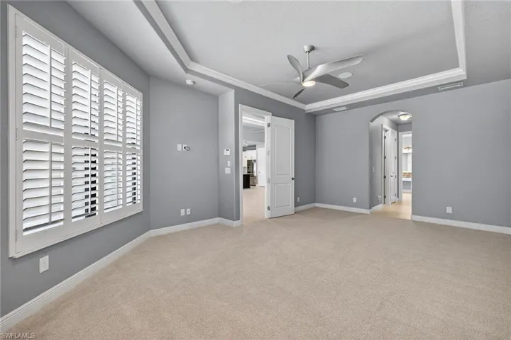 Primary Suite Trayed ceiling and fan with plantation shutters