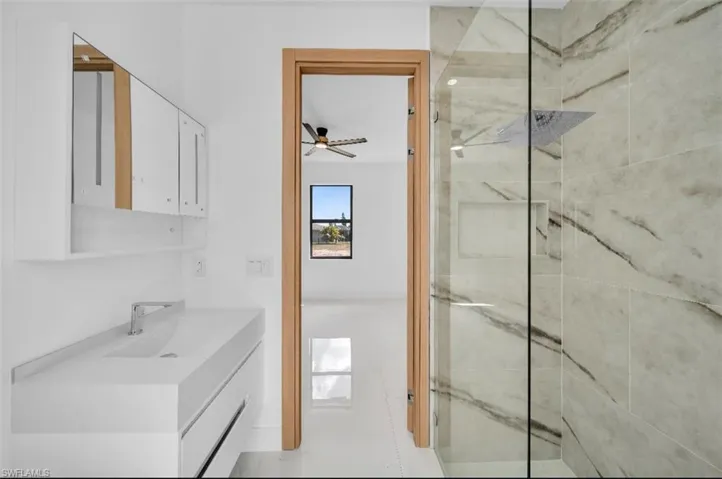 Bathroom featuring a tile shower and vanity