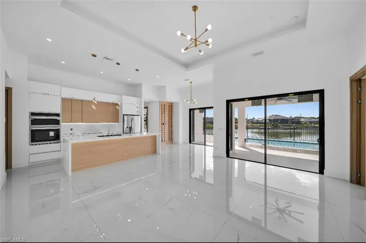 Kitchen with an inviting chandelier, decorative light fixtures, and stainless steel appliances