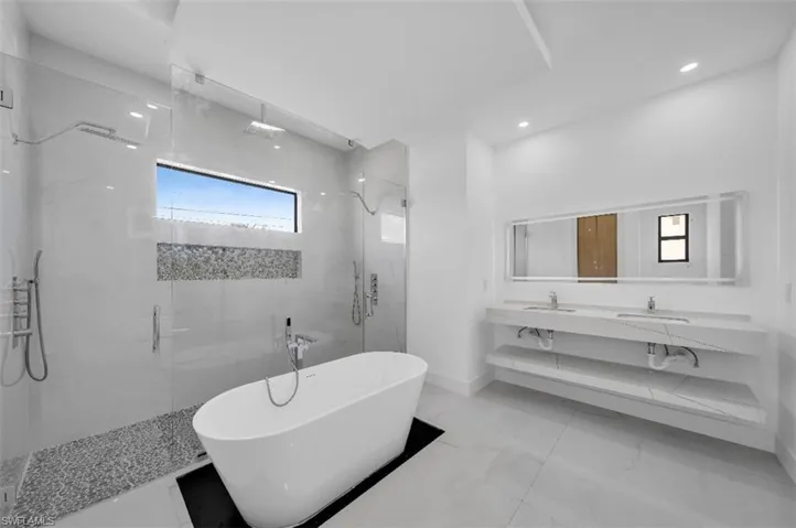 Bathroom featuring vanity and independent shower and bath