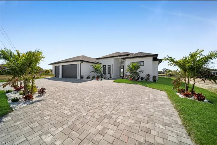 View of front of property featuring a garage and a front lawn