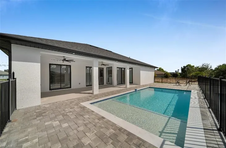 View of pool with ceiling fan and a patio