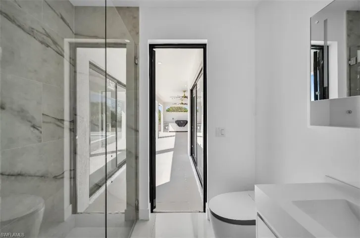 Bathroom featuring an enclosed shower, vanity, and toilet