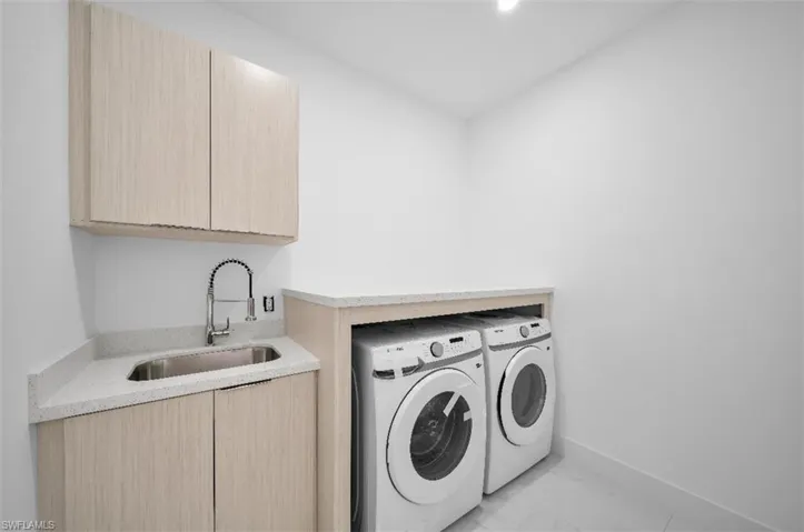 Laundry area with cabinets, sink, and independent washer and dryer