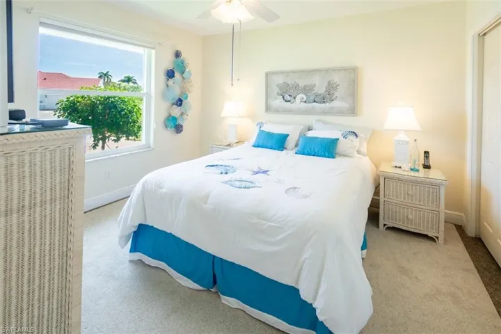 Carpeted bedroom featuring ceiling fan