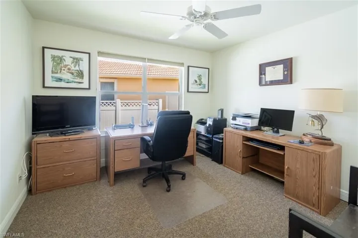 Office area featuring light carpet and ceiling fan
