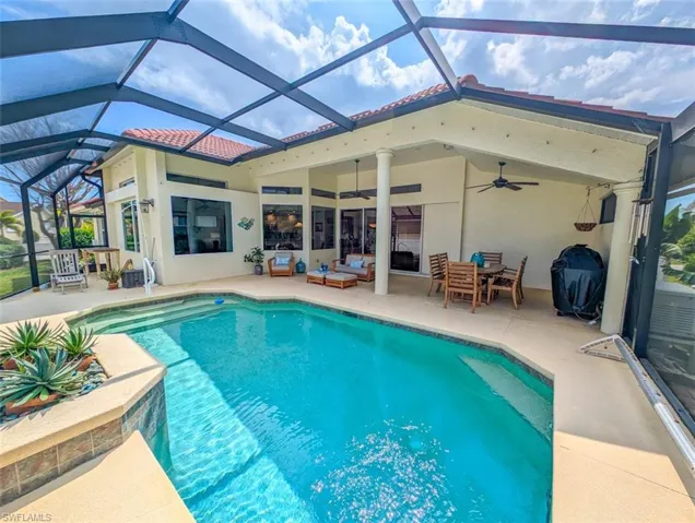 View of swimming pool with grilling area, outdoor lounge area, a lanai, a patio area, and ceiling fan