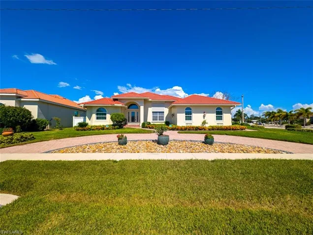 Mediterranean / spanish home featuring a front lawn