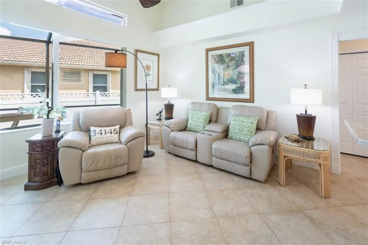 Living room featuring light tile patterned flooring and a towering ceiling