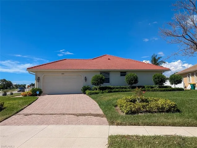 Mediterranean / spanish-style home with a front lawn and a garage