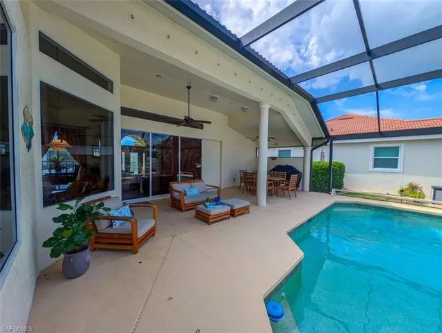 View of pool with a patio, an outdoor living space, a lanai, and ceiling fan