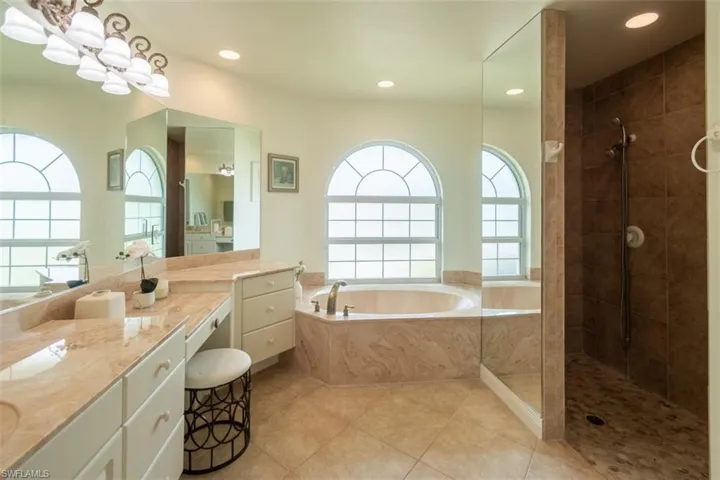 Bathroom with vanity, separate shower and tub, and tile patterned flooring