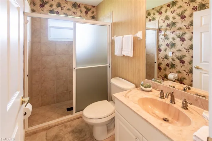 Bathroom featuring vanity, toilet, and walk in shower