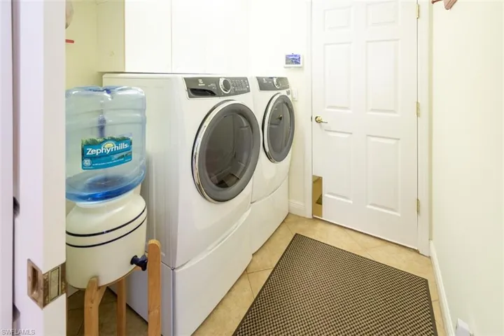 Laundry room featuring washer and clothes dryer and light tile patterned floors