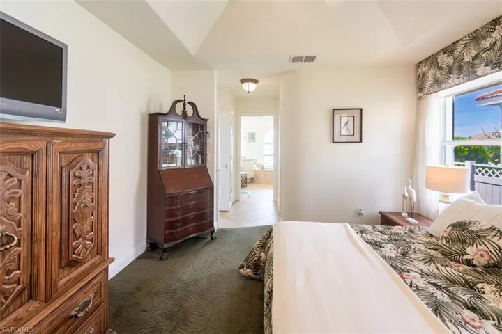 Carpeted bedroom featuring ensuite bathroom