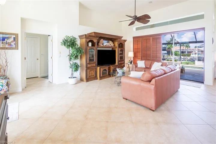 Tiled living room featuring a towering ceiling and ceiling fan