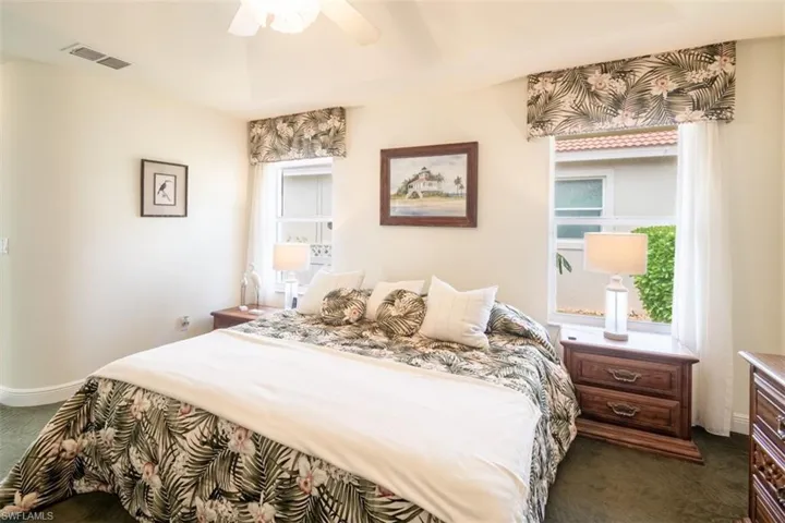 Carpeted bedroom featuring ceiling fan