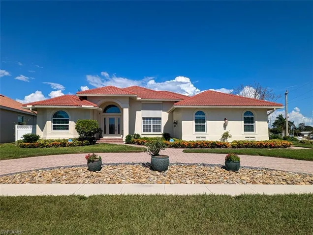 Mediterranean / spanish house with a front lawn
