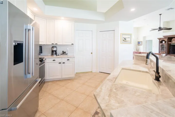 Kitchen featuring sink, white cabinetry, light tile patterned floors, appliances with stainless steel finishes, and ceiling fan