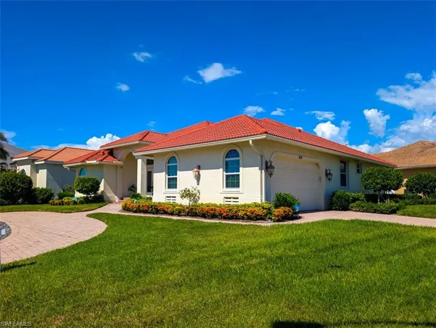Mediterranean / spanish house featuring a front yard and a garage