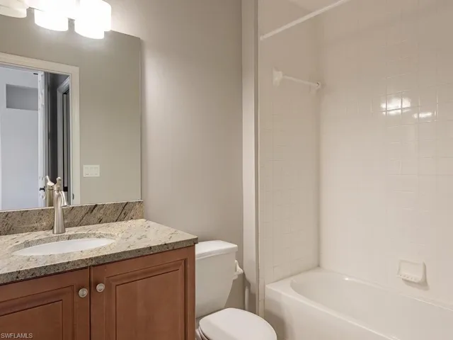 Full bathroom featuring vanity, toilet, and tiled shower / bath