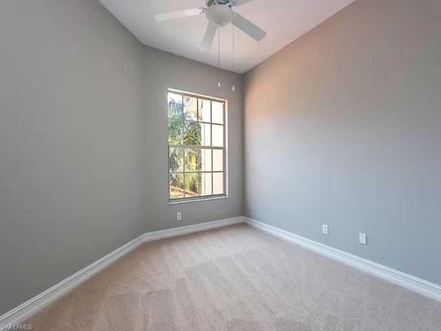 Carpeted spare room featuring ceiling fan