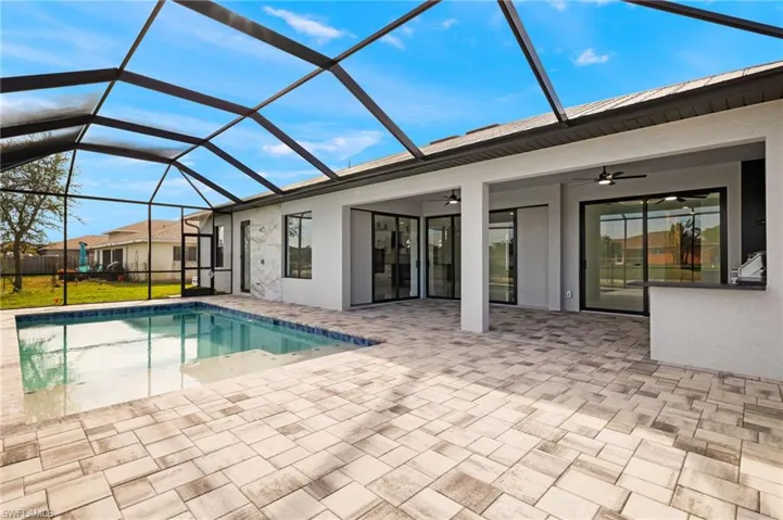 View of swimming pool featuring a lanai, a patio area, and ceiling fan