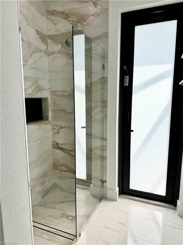 Bathroom featuring a marble finish shower and marble finish floor