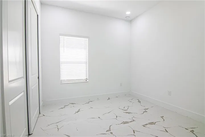 Unfurnished room with recessed lighting and light marble finish floors