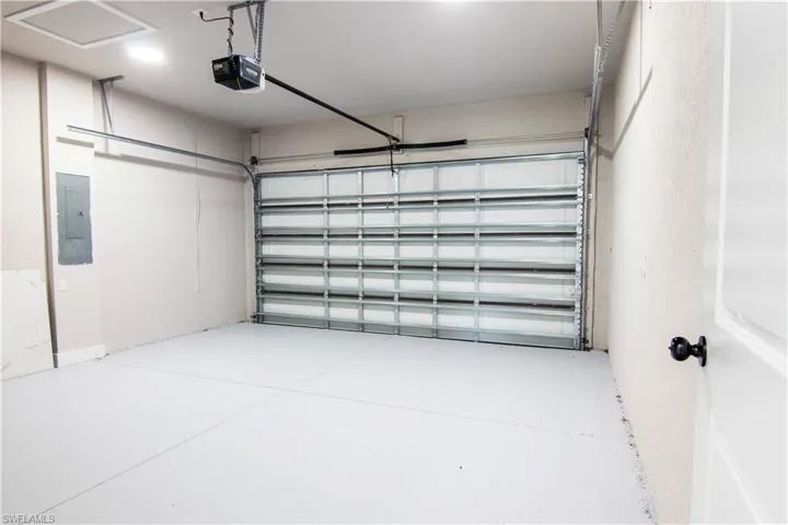 Garage featuring electric panel and a garage door opener