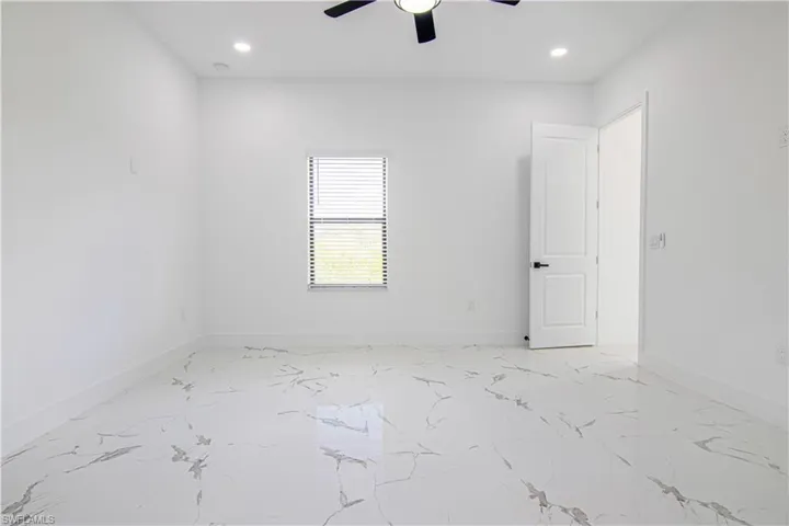 Unfurnished room featuring light marble finish flooring, recessed lighting, and a ceiling fan