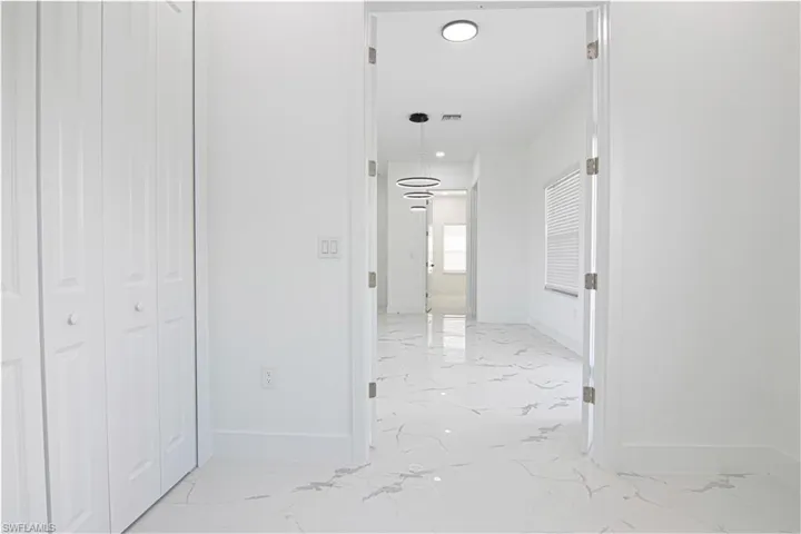 Hall with baseboards and light marble finish floors