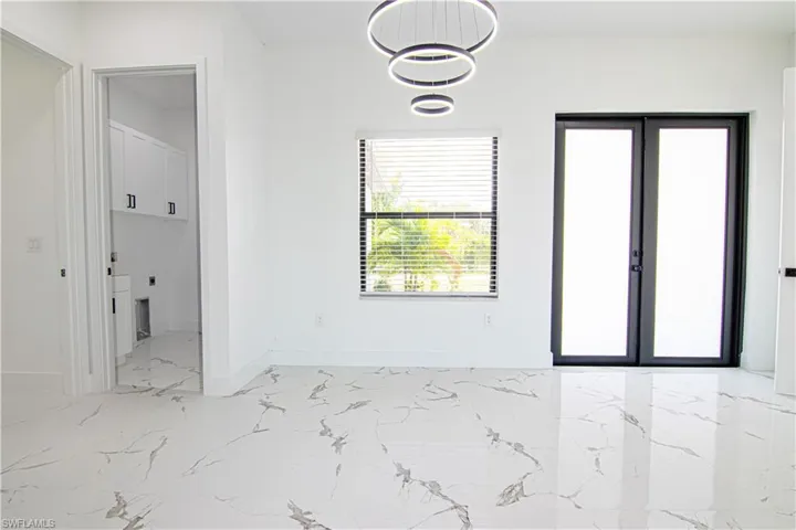 Spare room with light marble finish flooring and baseboards