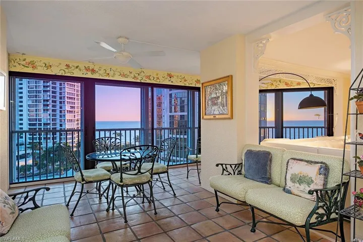 Dining space with a ceiling fan, a textured wall, a water view, and tile patterned flooring