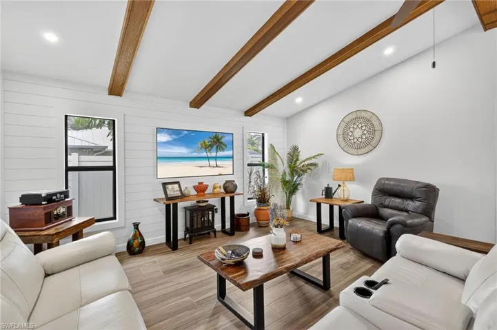 Living room with light wood finished floors, recessed lighting, and wood walls