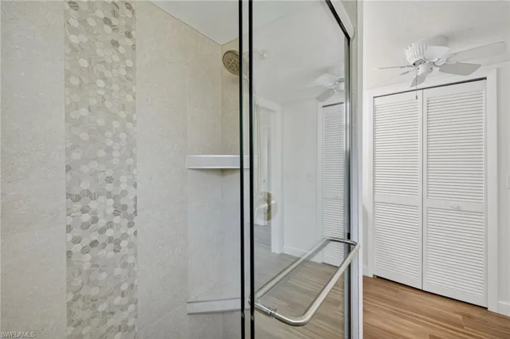 Bathroom featuring wood finished floors, a closet, and a shower