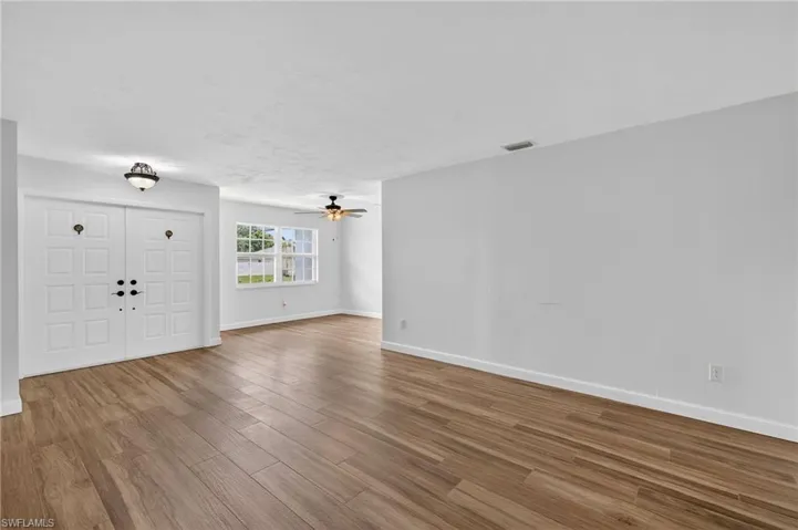 Unfurnished living room with wood finished floors and ceiling fan