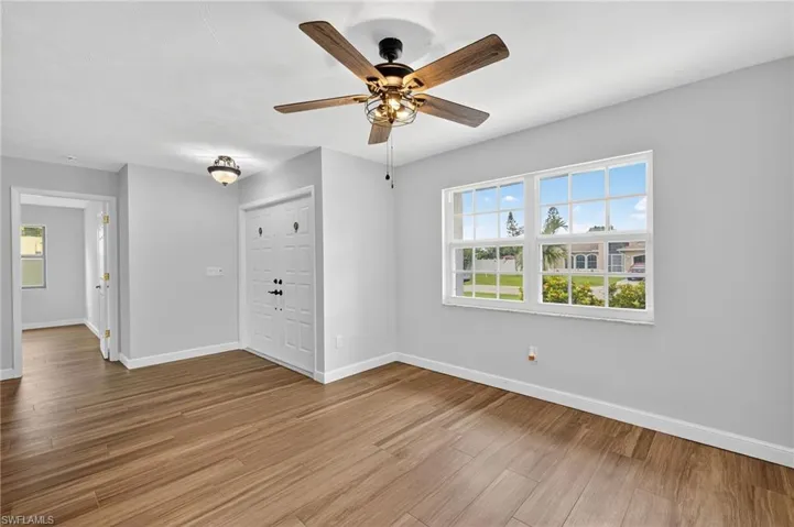 Unfurnished living room featuring light wood-type flooring and ceiling fan