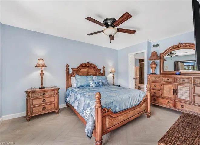 Absolutely beautiful bedroom with ensuite bath, light parquet floors, and ceiling fan, with a television!