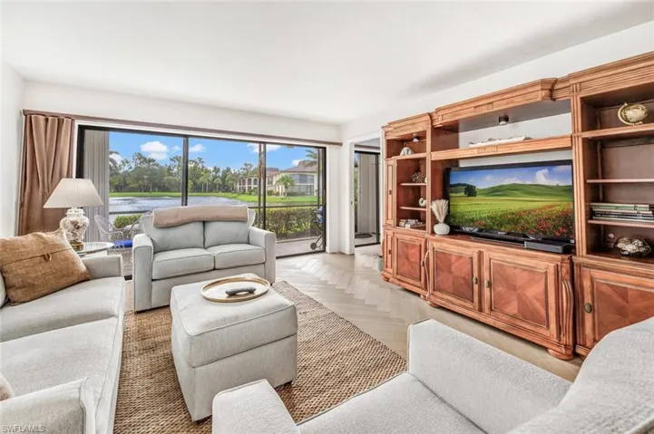 Living room featuring light parquet flooring, beautifiul wood furniture to finish the warmth.  Great sliding privacy cover that sides over expansive sliding doors.
