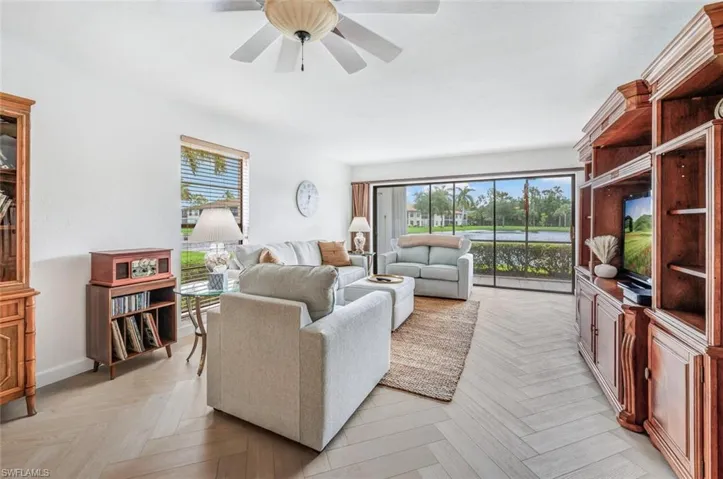 Living room with ceiling fan, plenty of natural light, and light parquet floors-new couch, loveseat and chair in such a pleasant color.