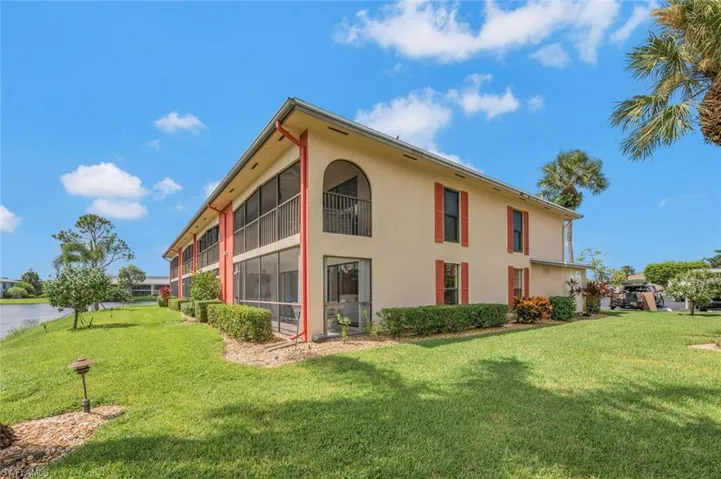 Rear view of building featuring nice lawn area.