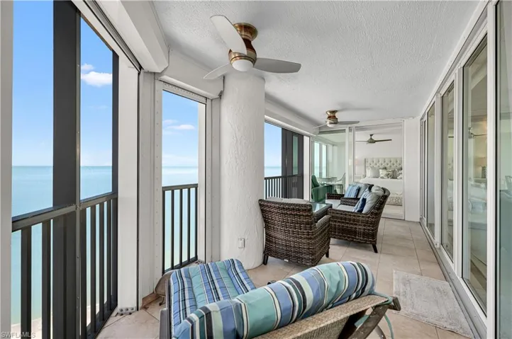 Sunroom with a water view and a ceiling fan
