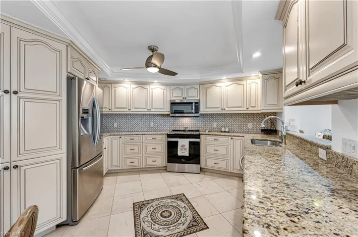 Kitchen featuring a sink, stainless steel appliances, tasteful backsplash, and ceiling fan