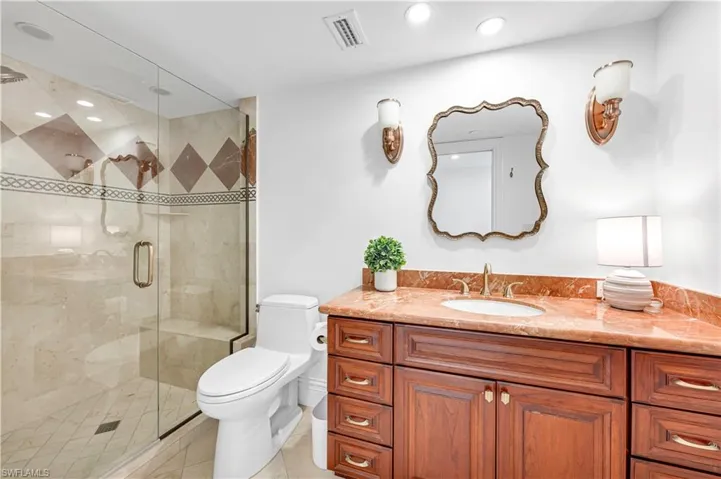 Full bathroom featuring tile patterned floors, toilet, a shower stall, and vanity