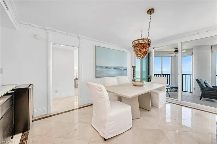 Dining room featuring marble finish floor, baseboards, and ornamental molding